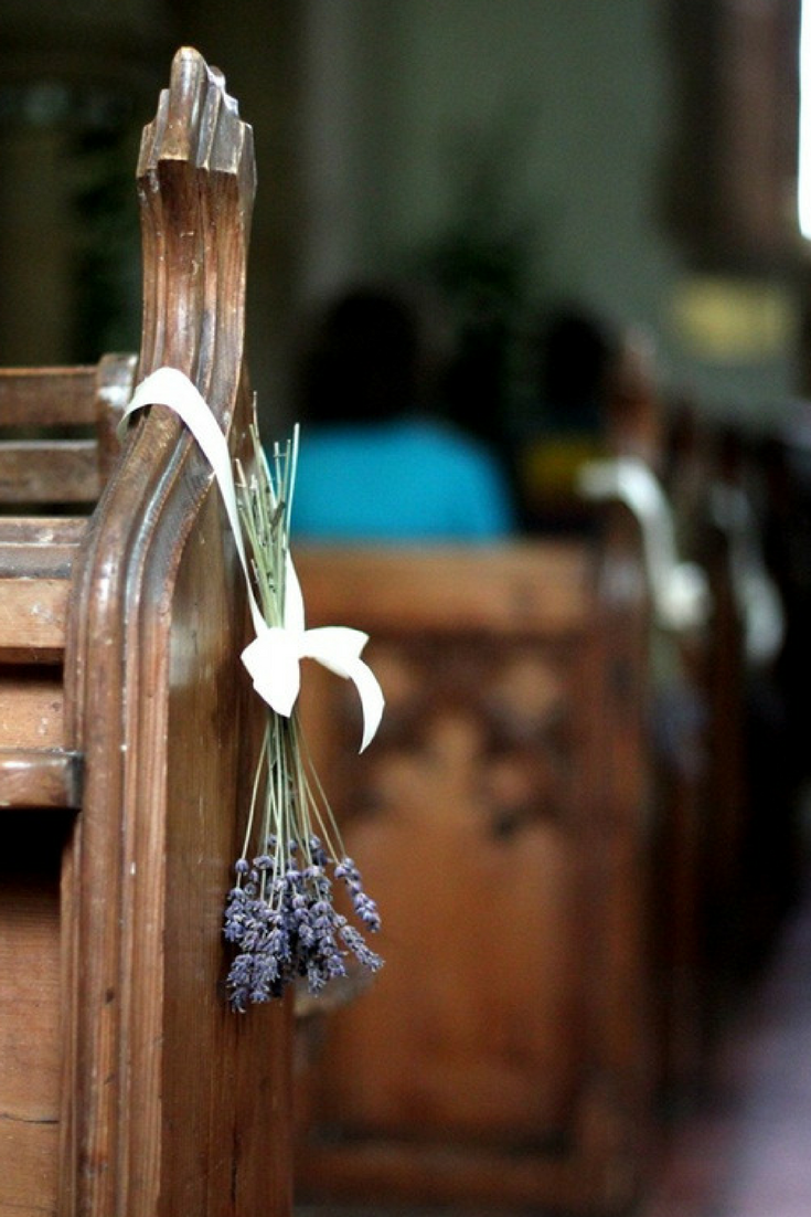 lavender bunches hanging from pew for wedding